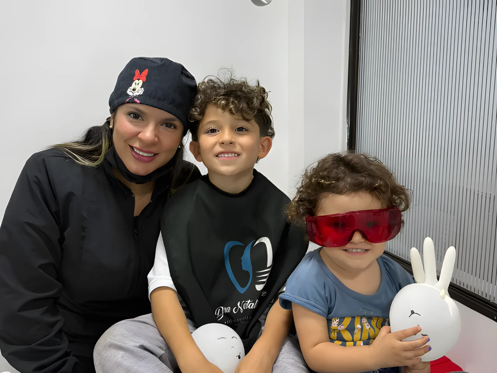 La Dra. Natalia Gómez con dos niños pacientes en el consultorio